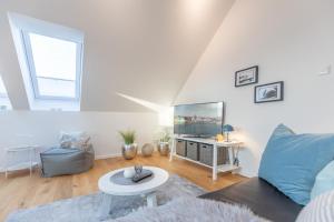 a living room with a couch and a tv at Penthouse Tine in Husum