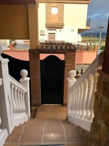 una escalera que conduce a una puerta negra de una casa en Casa Emilio, en Pulianas