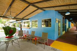 Zimmer mit einem Tisch und Stühlen sowie einer blauen Wand in der Unterkunft Villas del Caribe in Puerto Viejo