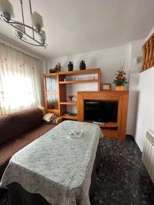 a living room with a table and a tv at Casa Emilio in Pulianas