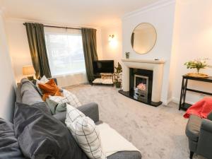 a living room with a couch and a fireplace at Maple House in Tadcaster