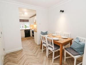 a kitchen and dining room with a wooden table and chairs at Maple House in Tadcaster