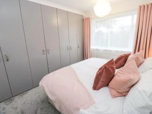 a bedroom with white cabinets and a bed with pillows at Maple House in Tadcaster