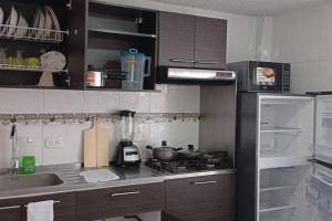 cocina con fregadero y fogones horno superior en Apartamento muy amplio, Familiar cerca al Aeropuerto el Dorado, en Bogotá