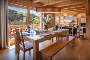 a dining room with a table and a large window at Chalet Le Charmieux - OVO Network in Le Grand-Bornand