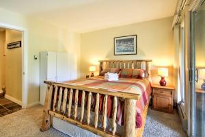 ein Schlafzimmer mit einem Holzbett und einem Kühlschrank in der Unterkunft Cozy Ski-inandSki-out Condo on Bretton Woods Ski Mtn in Carroll