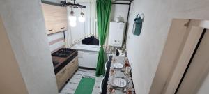 eine kleine Küche mit grünen Vorhängen und einem Tisch in der Unterkunft Studio OnE Lupeni in Lupeni