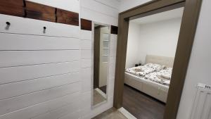 - une chambre avec un miroir et un lit dans l'établissement Relax Apartments Sárvár A2, à Sárvár