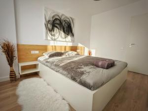 a bedroom with a large white bed with a rug at Cluj Airport Apartment in Cluj-Napoca