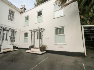 una casa blanca con aparcamiento en The White House, en Torquay