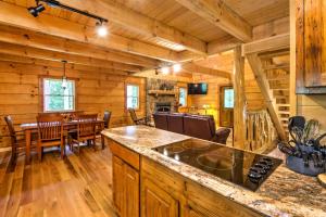 a kitchen and dining room in a log cabin at Scenic Trade Cabin with Deck Near Boone and App State! in Trade
