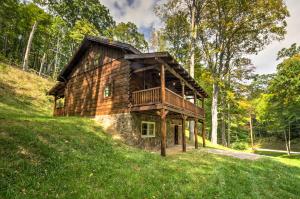 a log cabin in the middle of a grassy hill at Scenic Trade Cabin with Deck Near Boone and App State! in Trade