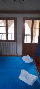 a blue bed in a room with two windows at ΠΑΝΟΡΑΜΑ ΤΣΕΠΕΛΟΒΟΥ in Tsepelovo