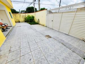 eine leere Einfahrt mit Zaun und Garage in der Unterkunft Quartos com Banheiros privativos - Hospedagem Recanto do Luar in Taubaté