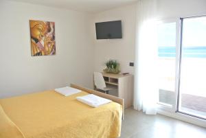 a bedroom with a yellow bed and a window at Hotel Touring in Misano Adriatico