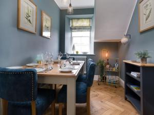 a dining room with a table and blue chairs at Wansfell at Lipwood House in Windermere