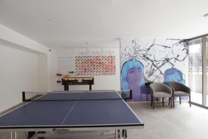 a ping pong table in a room with a mural at LivinnX Santiago in Santiago
