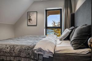 una camera da letto con un letto grande con una finestra di Unique villa by The Norwegian Coast. Private spa a Lokøy Altre 51 foto