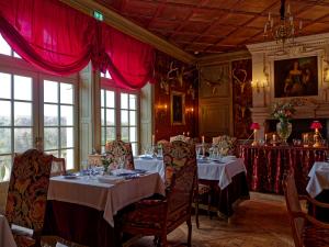 ReugnyRelais & Château Louise de La Vallière的一间配备有桌椅和红色窗帘的用餐室