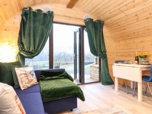 a living room with a blue couch and a desk at The Shearer - Crossgate Luxury Glamping in Penrith