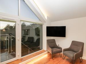 sala de estar con 2 sillas y TV de pantalla plana en Upper Annex en Calne