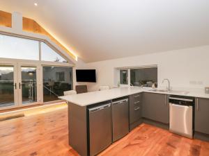 an open kitchen with stainless steel appliances and a large window at Upper Annex in Calne