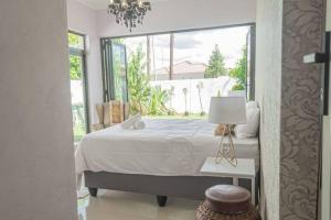 a bedroom with a bed and a large window at Ellen Topo in Gaborone