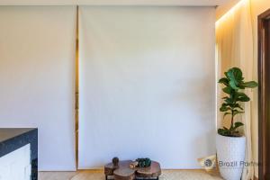 ein Wohnzimmer mit einem Kamin und einer Pflanze in der Unterkunft Taíba Beach Resort - Apartamento Encantador! in São Gonçalo do Amarante