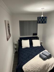 a bedroom with a blue bed with two pillows at Rhyl beach town apartment in Rhyl