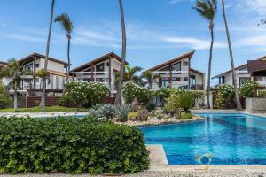 ein Resort mit Swimmingpool und Palmen in der Unterkunft Taíba Beach Resort - Apartamento Encantador! in São Gonçalo do Amarante