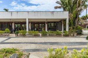 ein Gebäude mit Glastüren und Pflanzen im Innenhof in der Unterkunft Taíba Beach Resort - Apartamento Encantador! in São Gonçalo do Amarante
