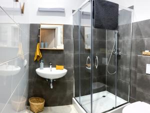 a bathroom with a glass shower and a sink at Chummy House Sopot in Sopot