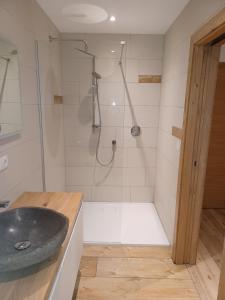 een badkamer met een douche en een zwarte wastafel bij kuglerhof in Dobbiaco
