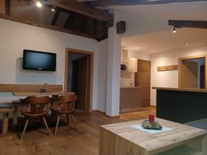 a living room with a table and a tv on the wall at kuglerhof in Dobbiaco