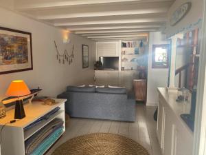 een woonkamer met een bank en een tafel bij Bungalow Anolis face à la mer à 2 min de la plage. in Terre-de-Haut
