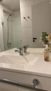 a bathroom sink with a mirror and a vase of flowers at HOME DOS MARTIN a 1 cuadra de peatonal in Resistencia +18 photos