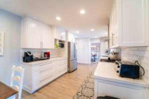 a kitchen with white cabinets and a counter top at Private Pool Oasis/Disney 15mins /Disney+ HBO/Gym in Placentia