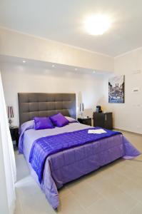 a bedroom with a large bed with purple sheets at Domus Fontis in Rome