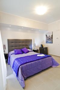 ローマにあるドームス フォンティのベッドルーム1室(紫のシーツが敷かれた大型ベッド1台付)