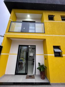 Maison jaune et blanche avec fenêtre dans l'établissement Chalé Amarelo, à Itanhaém