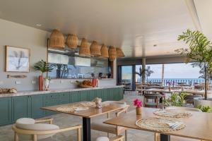 ein Restaurant mit Tischen und Stühlen und Meerblick in der Unterkunft Saline Taíba Boutique Beach Hotel in Taíba