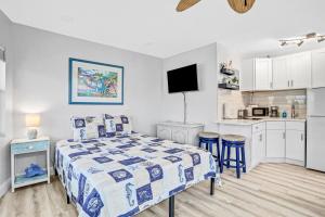 a small bedroom with a bed and a kitchen at Sea Rocket 21 in St Pete Beach