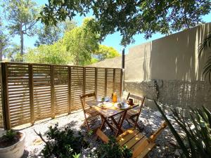 una mesa y sillas en un patio trasero con una valla en Studios Aromas do Campeche - Floripa, en Florianópolis