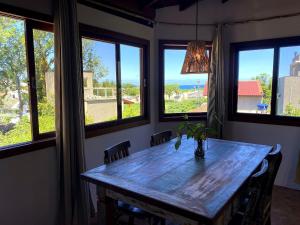 una mesa de comedor con un jarrón y ventanas en Studios Aromas do Campeche - Floripa, en Florianópolis