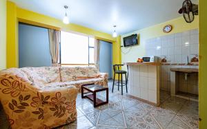 a living room with a couch and a kitchen at Hotel Costa Norte in Chiclayo