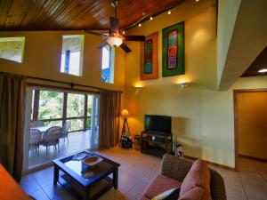 - un salon avec un canapé et un ventilateur de plafond dans l'établissement Casa Buena Vida, à West Bay