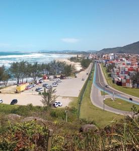 a view of a parking lot next to the beach at Apartamento encantador próximo praia mercado Farm padaria in Imbituba
