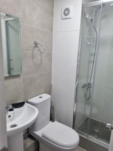 a bathroom with a toilet and a shower and a sink at Departamento en Tome, Condominio Vista Bahia in Tomé