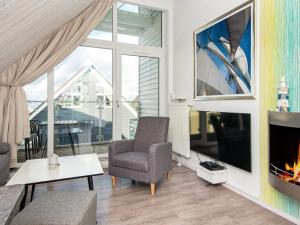 un soggiorno con camino e sedia di Two-Bedroom Holiday home in Wendtorf 37 a Wendtorf