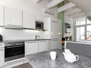 una cocina con armarios blancos y una mesa con tazas. en 4 person holiday home in Wendtorf, en Wendtorf